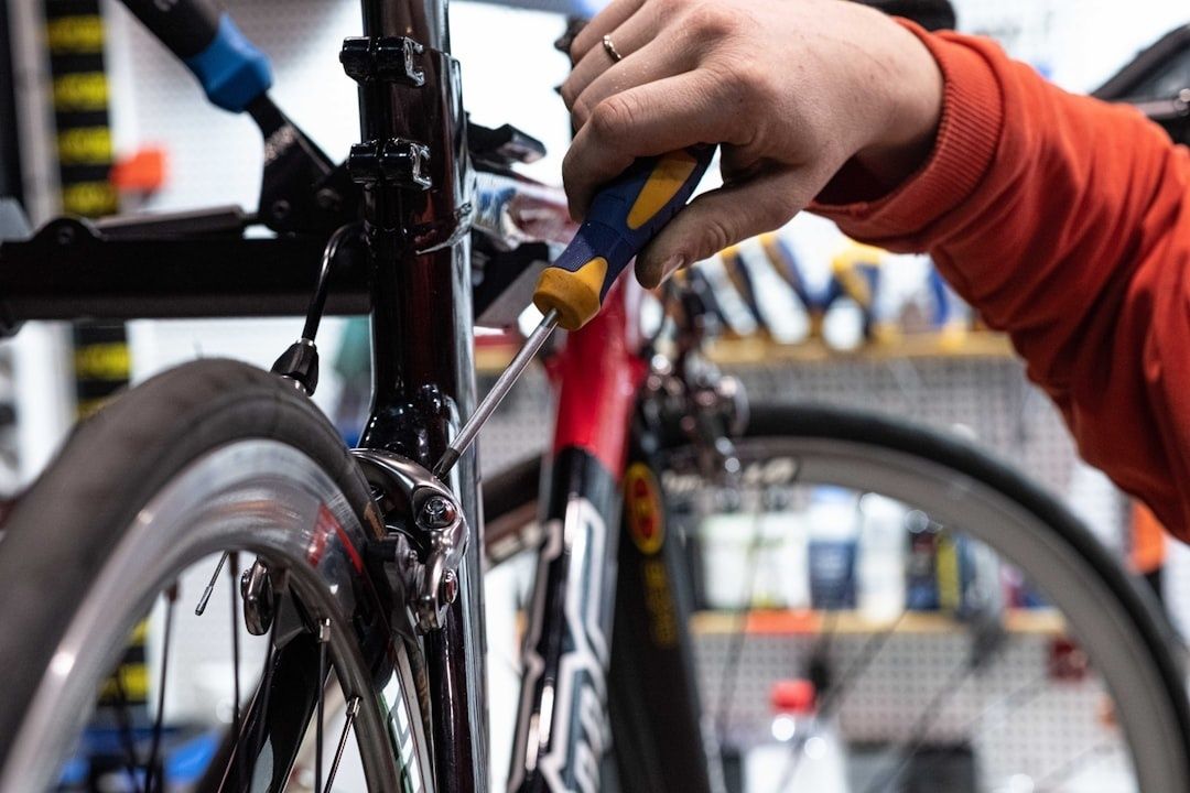 Person justerar en cykels broms med skruvmejsel i verkstad